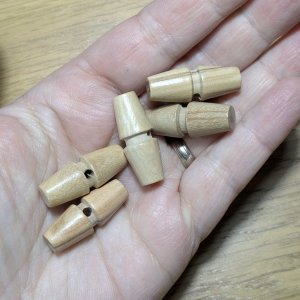 Five 30 mm olive wood toggle buttons displayed in a row